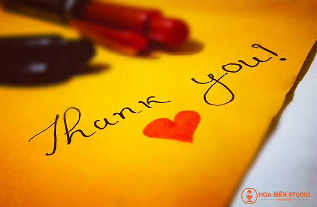 chữ thank you với hình trái tim bên dưới được vẽ trên tờ giấy màu vàng